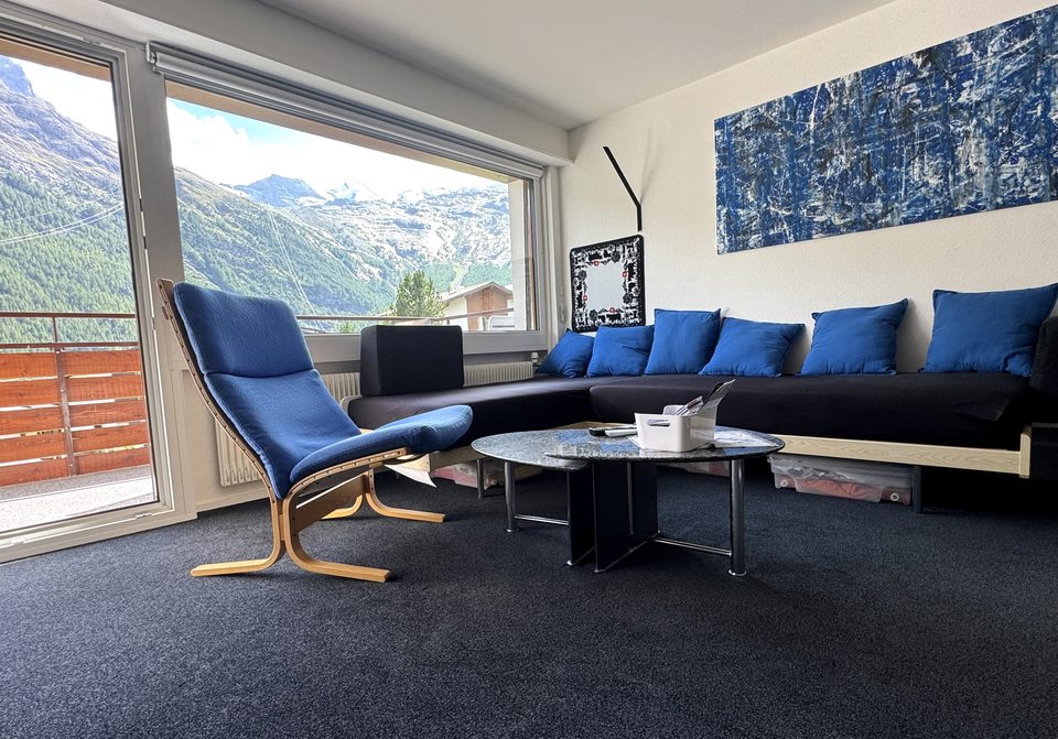 Le séjour en journée, avec la baie vitrée et la vue sur les montagnes